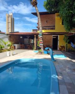 a swimming pool in front of a house at Pousada Flor D' Açucena in Natal