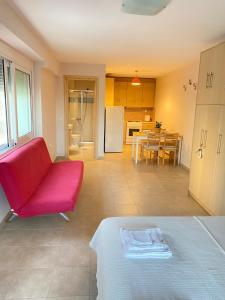 een woonkamer met een rode stoel en een keuken bij Seaside one-bedroom on Chalkis in Chalkida