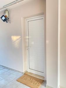 a white door in a room with a rug at Seaside one-bedroom on Chalkis in Chalkida