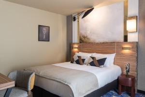 a hotel room with a bed and a lamp at Le Rocroy Hotel Paris Gare du Nord in Paris