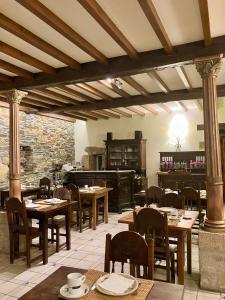 restauracja z drewnianymi stołami i krzesłami w pokoju w obiekcie Pazo da Trave w mieście Viveiro