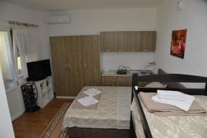 a living room with two beds and a kitchen at Apartments Frau Trena in Gevgelija