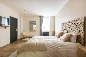een slaapkamer met een groot wit bed in een kamer bij Studio chic avec salon et terrasse privée in Tourcoing