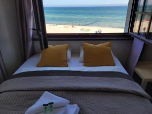 a bedroom with a bed with a view of the beach at Dom Przy Plaży in Sarbinowo