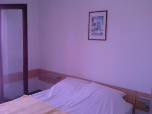 a bedroom with purple walls and a bed with a mirror at Apartments Meni in Drage