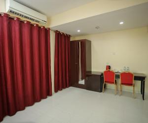 a room with red curtains and a table with red chairs at Al Sharq Hotel in Sharjah