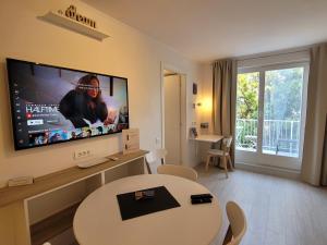 uma sala de estar com uma mesa e uma televisão de ecrã grande em Villa Yadranka II Sea view terrace em Strunjan