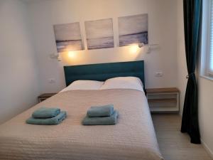 um quarto com uma cama com duas almofadas em Villa Yadranka II Sea view terrace em Strunjan