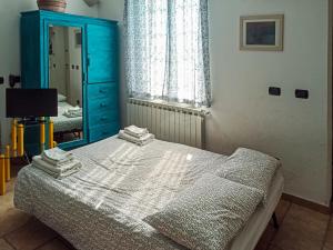 1 dormitorio con 1 cama con tocador azul y espejo en La Casa di Anna ☆☆☆☆☆[Cogoleto - 100 metri dal MARE], en Cogoleto