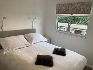 1 dormitorio con 1 cama blanca y 2 toallas en 310 Norton Park en Dartmouth