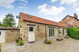 an exterior view of a stone cottage at Cow Byre Cottage in Snainton