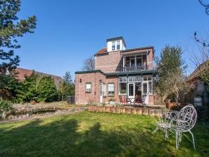 een groot bakstenen huis met een tafel en stoelen in de tuin bij Villa Lucia in Rucphen