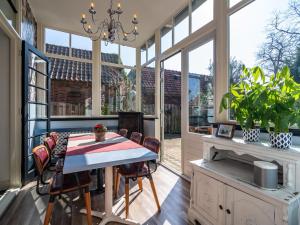 una veranda riparata con tavolo e sedie di Villa Lucia a Rucphen