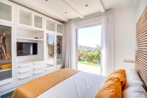 een slaapkamer met een bed, een tv en een raam bij Villa green Eden in Sorrento
