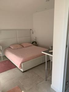 - une chambre avec un lit avec des draps roses et une table dans l'établissement Villa Elimia avec piscine chauffée, à Antibes