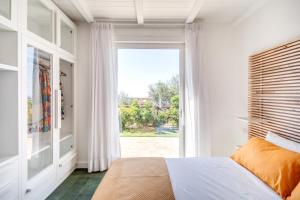 een slaapkamer met een bed en een groot raam bij Villa green Eden in Sorrento