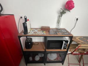 einen kleinen Tisch mit einer Mikrowelle darüber in der Unterkunft Estudio Jardines de Colón in Córdoba