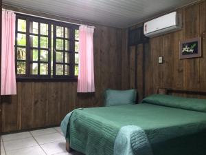a bedroom with a green bed and a window at Pousada do Oasis in Morretes +112 photos