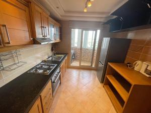 a kitchen with wooden cabinets and a stove top oven at PERLA NOUACEUR AéROPORT MOHAMMED V in Nouaceur
