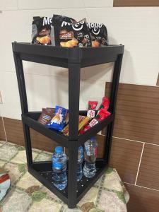 ein schwarzes Regal mit Getränken und Wasserflaschen darauf in der Unterkunft شقة مطلة علي قناة السويس701 in Port Said