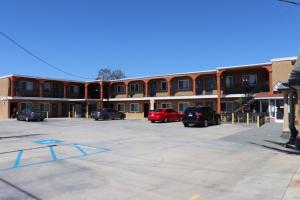 a parking lot with cars parked in front of a building at El Dorado Motel in Gardena