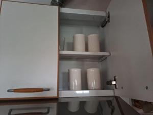 Un armario con un montón de tazas blancas. en BELLO SAN LUIS en San Luis