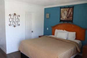 a bedroom with a bed and a blue wall at El Dorado Motel in Gardena