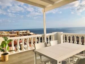 een balkon met een tafel en stoelen en de oceaan bij House Sofi , Morro Jable Ftvra. Canary Islands. in Morro del Jable