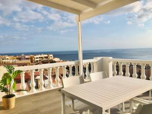 een balkon met een tafel en stoelen en de oceaan bij House Sofi , Morro Jable Ftvra. Canary Islands. in Morro del Jable