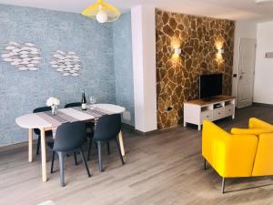 een eetkamer met een tafel, stoelen en een televisie bij House Sofi , Morro Jable Ftvra. Canary Islands. in Morro del Jable