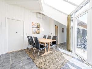 a dining room with a wooden table and chairs at 6 person holiday home in Vejers Strand in Vejers Strand +32 photos