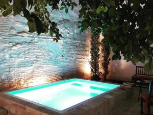 a swimming pool sitting next to a brick wall at Belvilla by OYO Casa Palacio de la Carrera in Fuentes de Andalucía