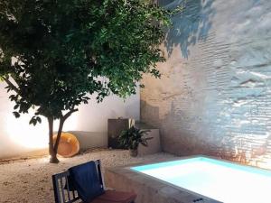 a swimming pool next to a tree next to a building at Belvilla by OYO Casa Palacio de la Carrera in Fuentes de Andalucía
