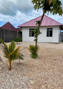 ein weißes Haus mit rotem Dach in der Unterkunft Amos House in Kendwa