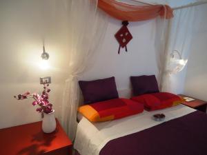 Dormitorio pequeño con cama con almohadas coloridas en Villa Dafne, en Bari