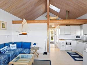 a living room with a blue couch and a kitchen at 8 person holiday home in STRÖMSTAD-By Traum in Strömstad +26 photos