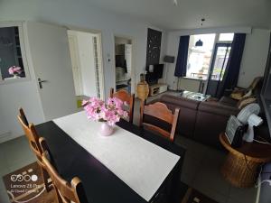 Una sala de estar con una mesa con un jarrón de flores encima. en Cozy house in Weert, en Weert