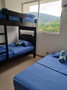 a bedroom with two bunk beds and a window at Hermoso apartamento en SANTA FE DE ANTIOQUIA in Medellín