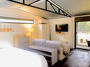 Habitación con sofá y TV. en Capri Retreat - For Couples, en Saint Andrews Beach