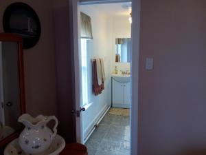 a bathroom with a sink and a vase in a hallway at The Spaniards Room Heritage Home in Spaniards Bay +29 photos