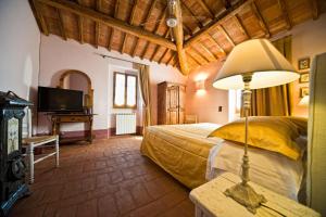 a bedroom with a bed and a lamp on a table at B&B Le Dimore Mezza Costa in San Casciano in Val di Pesa