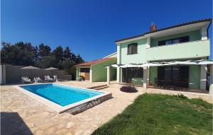 une maison avec une piscine devant une maison dans l'établissement Nice Home In Liznjan With Wifi, à Ližnjan