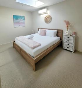 a bedroom with a large bed and a dresser at Waters Edge Apartment in Rye