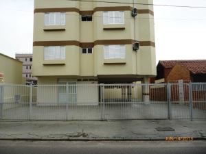 un edificio con una valla delante de un edificio en Residencial João Brollo, en Florianópolis