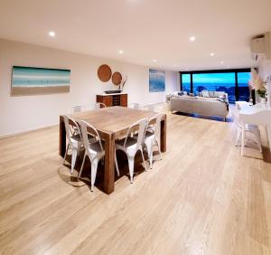 a dining room with a table and chairs and a couch at Waters Edge Apartment in Rye