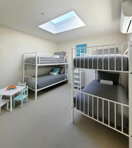 a room with two bunk beds and a table at Waters Edge Apartment in Rye