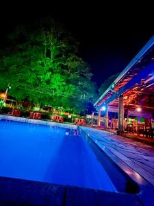 an empty swimming pool at night with lights at Ananda pousada chalé in São Pedro