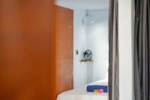 1 dormitorio con cama y espejo en Waiwas Hostel, en Kuta Lombok