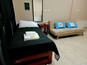 a hotel room with a bed and a couch at Departamento Sarmiento in Rosario de la Frontera