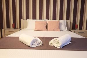 two towels on a bed with two pillows on it at Lira Beach Studio in Mamaia